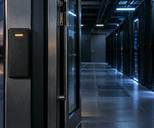 Synthetic editorial illustration. Unbranded access-control reader at the entrance to a dim data-centre corridor for cybersecurity and resilience news.