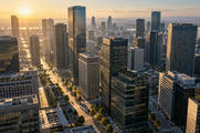 Synthetic editorial illustration. An elevated view looks across rectangular office towers and a grid of streets. Low morning sunlight warms the facades and throws long shadows between buildings.