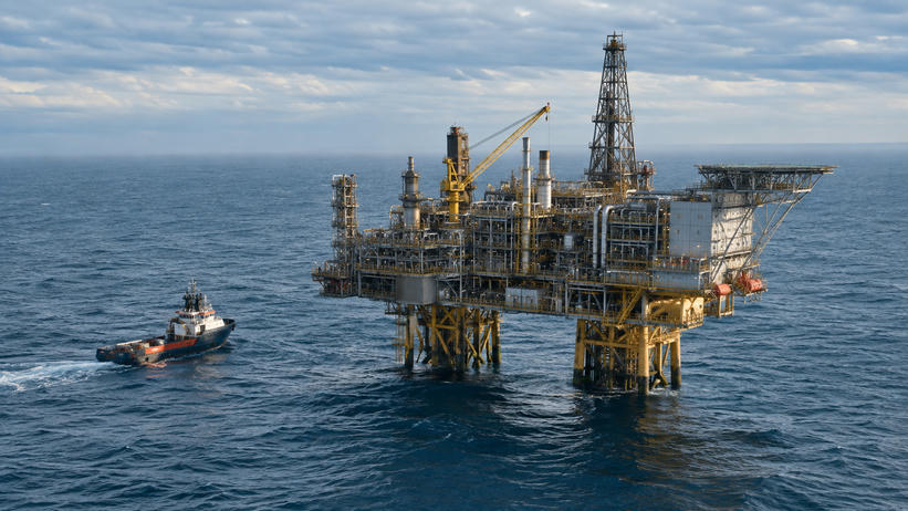 Synthetic editorial illustration. Generic offshore energy platform with processing pipework and a small service vessel on a calm sea; no real named facility or discovery.
