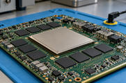 Synthetic editorial illustration. A large square metal-capped processor sits among smaller black chip packages and other components on a green circuit board. The board rests on a blue anti-static mat beside a grounding lead.