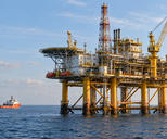 Synthetic editorial illustration. An offshore platform is framed over open water with a service vessel standing off to one side.
