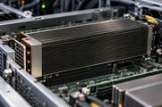 Synthetic editorial illustration. A finned accelerator assembly is seated within an open server chassis with connected circuitry and small equipment indicators.