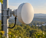 Synthetic editorial illustration. One plain telecommunications microwave dish is supported on a mast with a mounted bracket and routed cable.