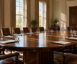 Synthetic editorial illustration. A formal cabinet room. An oval polished table is surrounded by empty brown leather chairs and set with plain folders and water glasses, while morning sunlight streams through tall curtained windows.