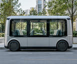 Synthetic editorial illustration. Generic purpose-built bidirectional passenger shuttle with symmetrical body, integrated discreet sensors and passenger seating but no visible steering wheel or driver controls; not a converted conventional passenger saloon. No actual named company, product, site, person or incident is depicted.