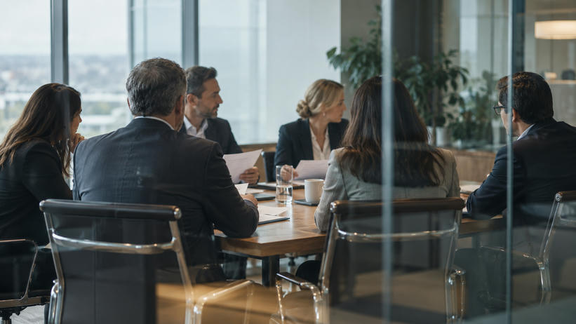Synthetic editorial illustration. A documentary view through glass into a corporate board meeting with anonymous executives seated naturally around an ordinary table, papers seen from blank backs, no theatrical empty throne or handshake.