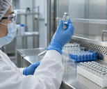 Synthetic editorial illustration. An anonymous pharmaceutical quality laboratory with a gloved scientist inspecting a sealed clear vial at a stainless bench, neatly ordered sample racks and clean equipment, no labels or syringes.